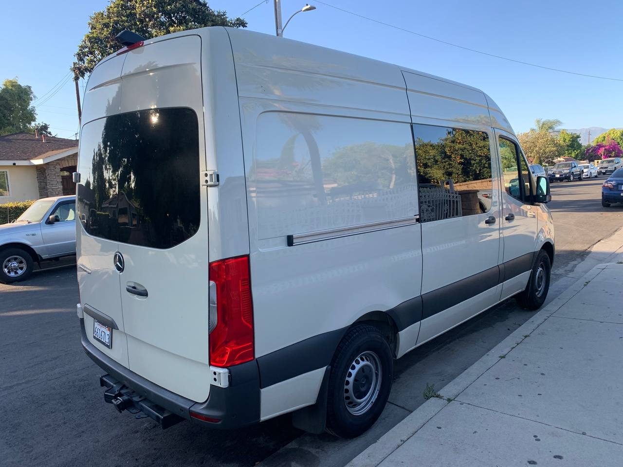 Rear view of the 5 seater crew cargo Sprinter showing the rear doors, tinted side windows and trailer hitch
