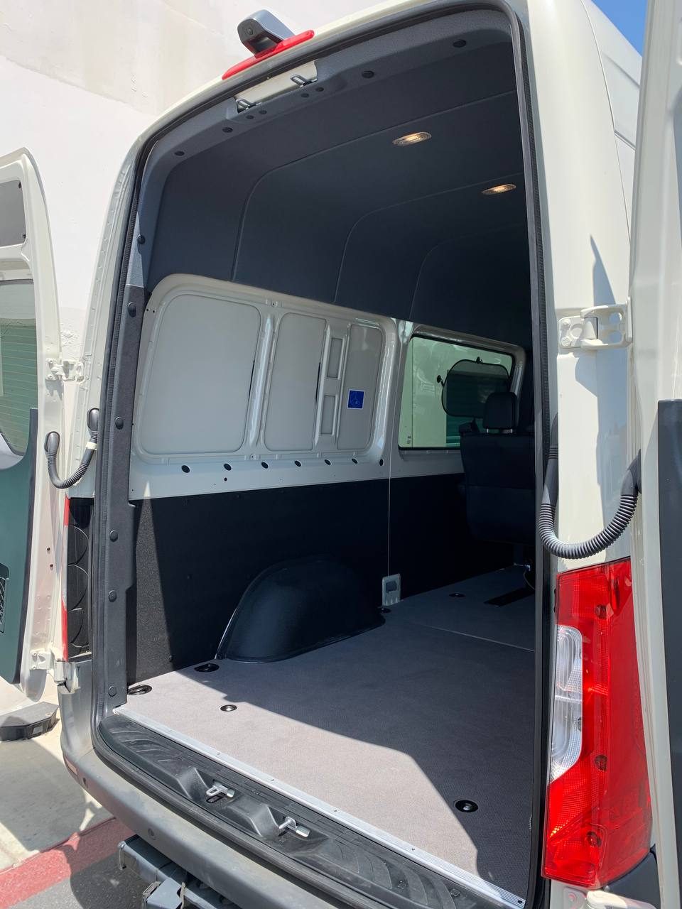 Rear doors open on the 144 WB crew cargo Sprinter, showing the cargo floor behind the last seat