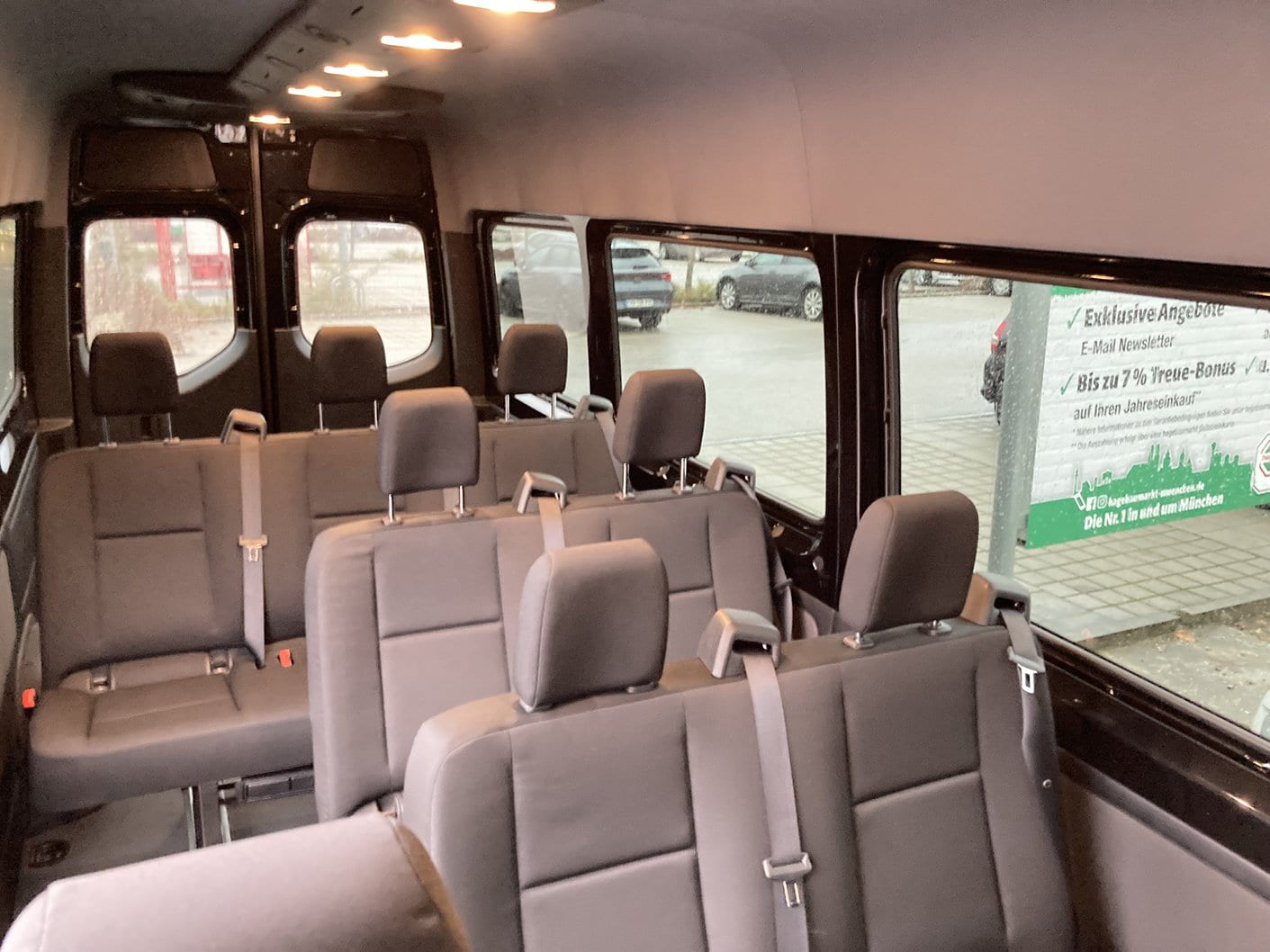 Interior of the 9 seater Sprinter EuroVan with cloth bench seats, headrests and seat belts