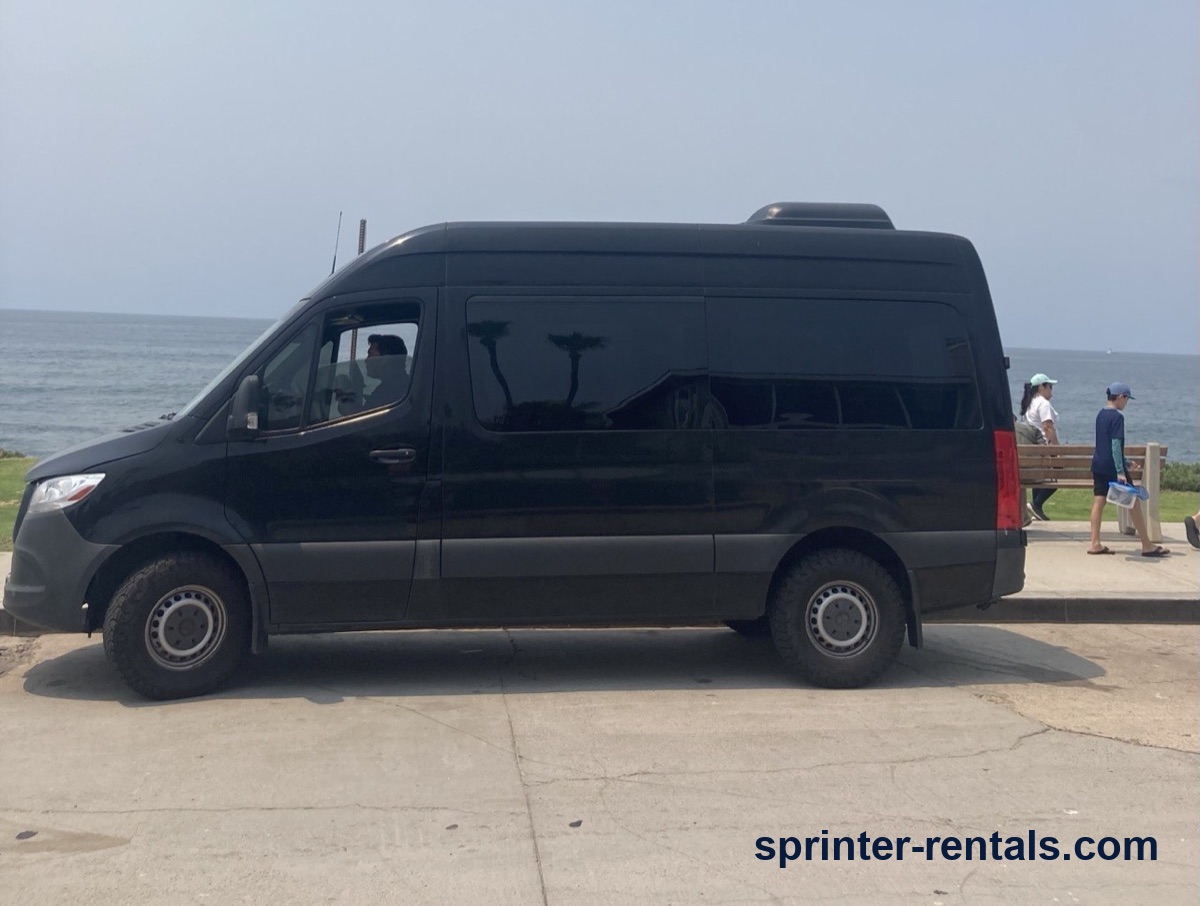 Black high roof Sprinter van parked along the coast on a beach day trip from Anaheim