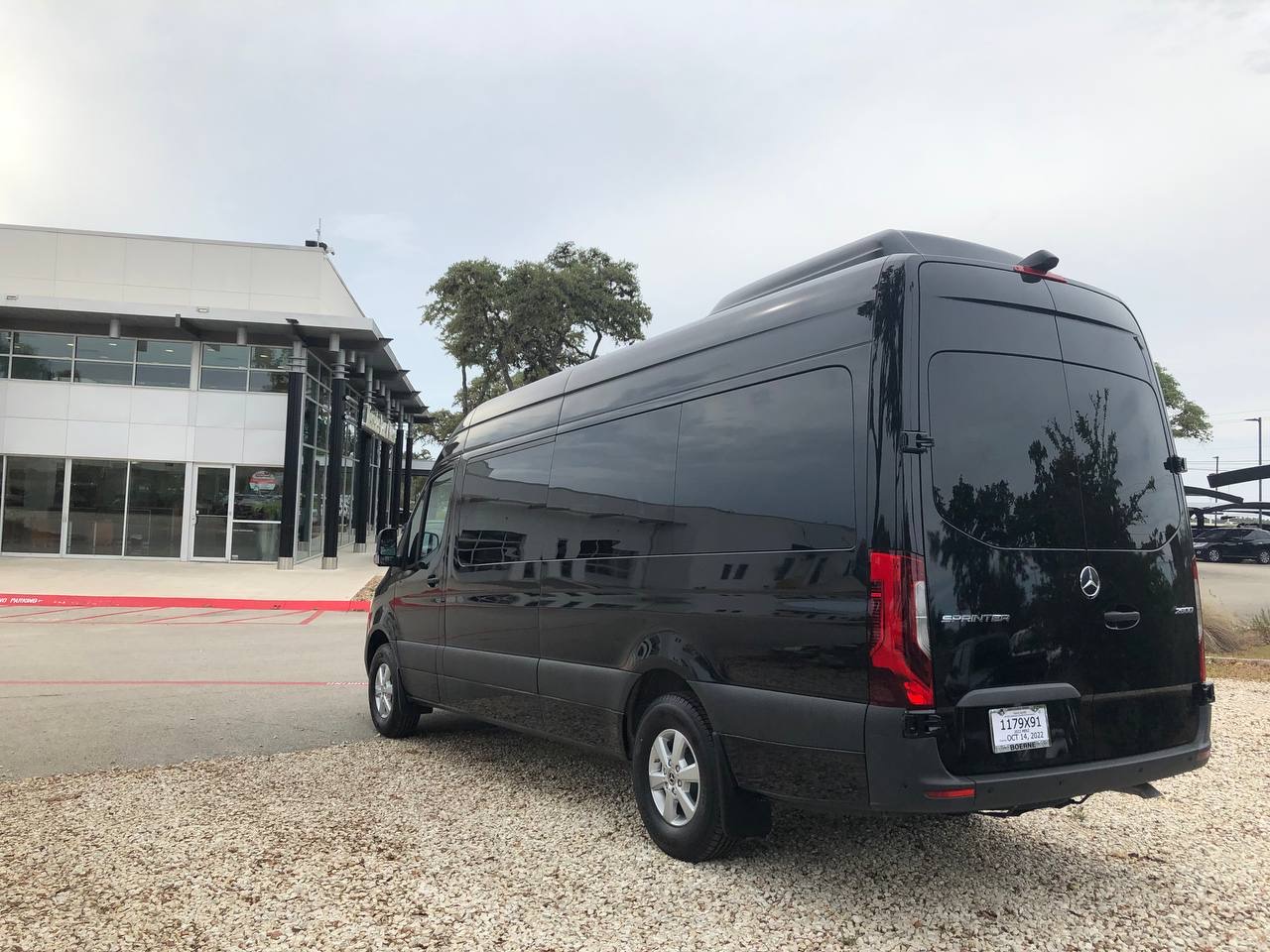 Black Mercedes Sprinter 15-passenger van rear three-quarter view at Austin pickup location