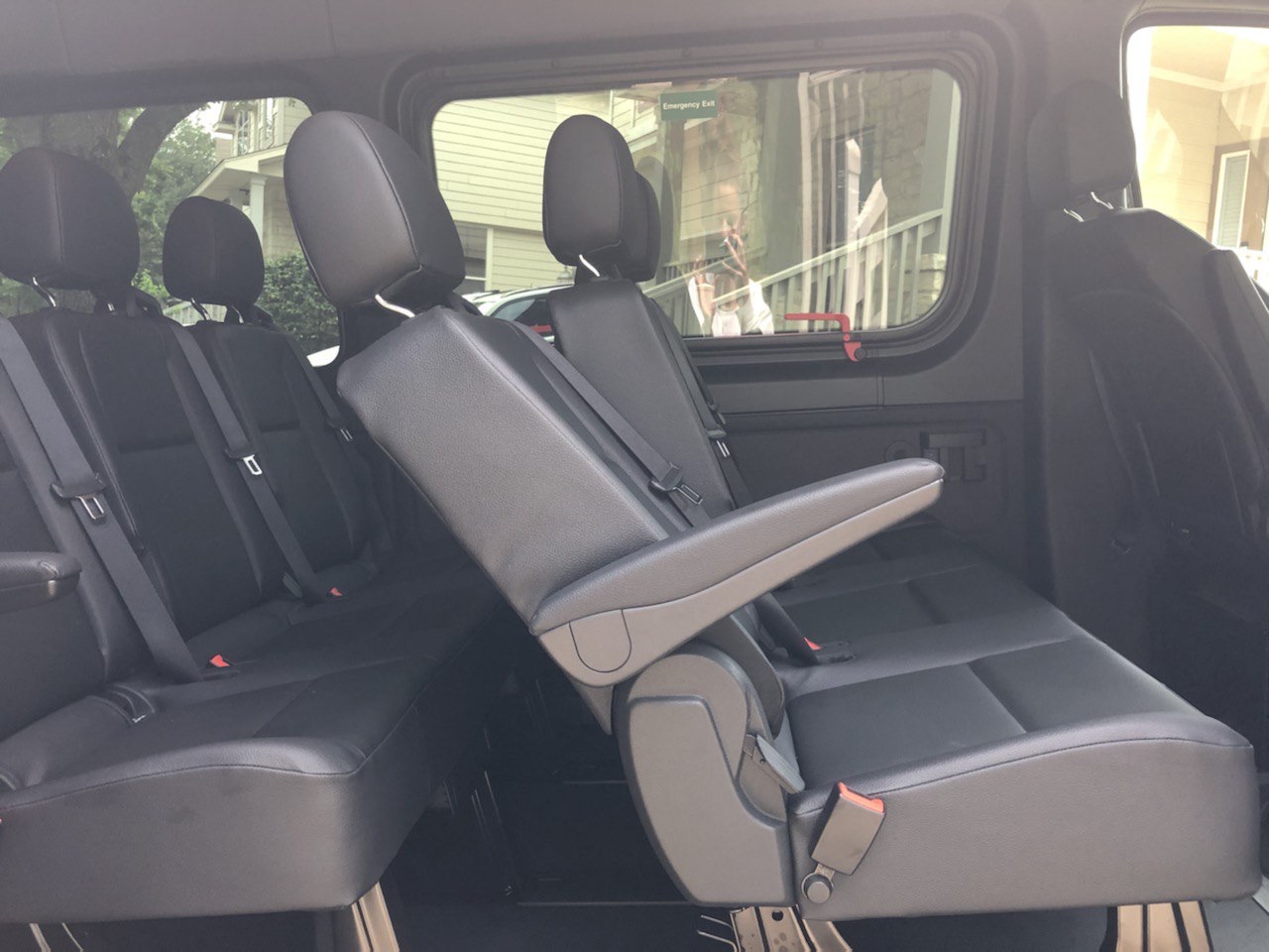 Sprinter passenger van interior with reclined captain chairs and rear bench — comfortable seating for Austin group travel