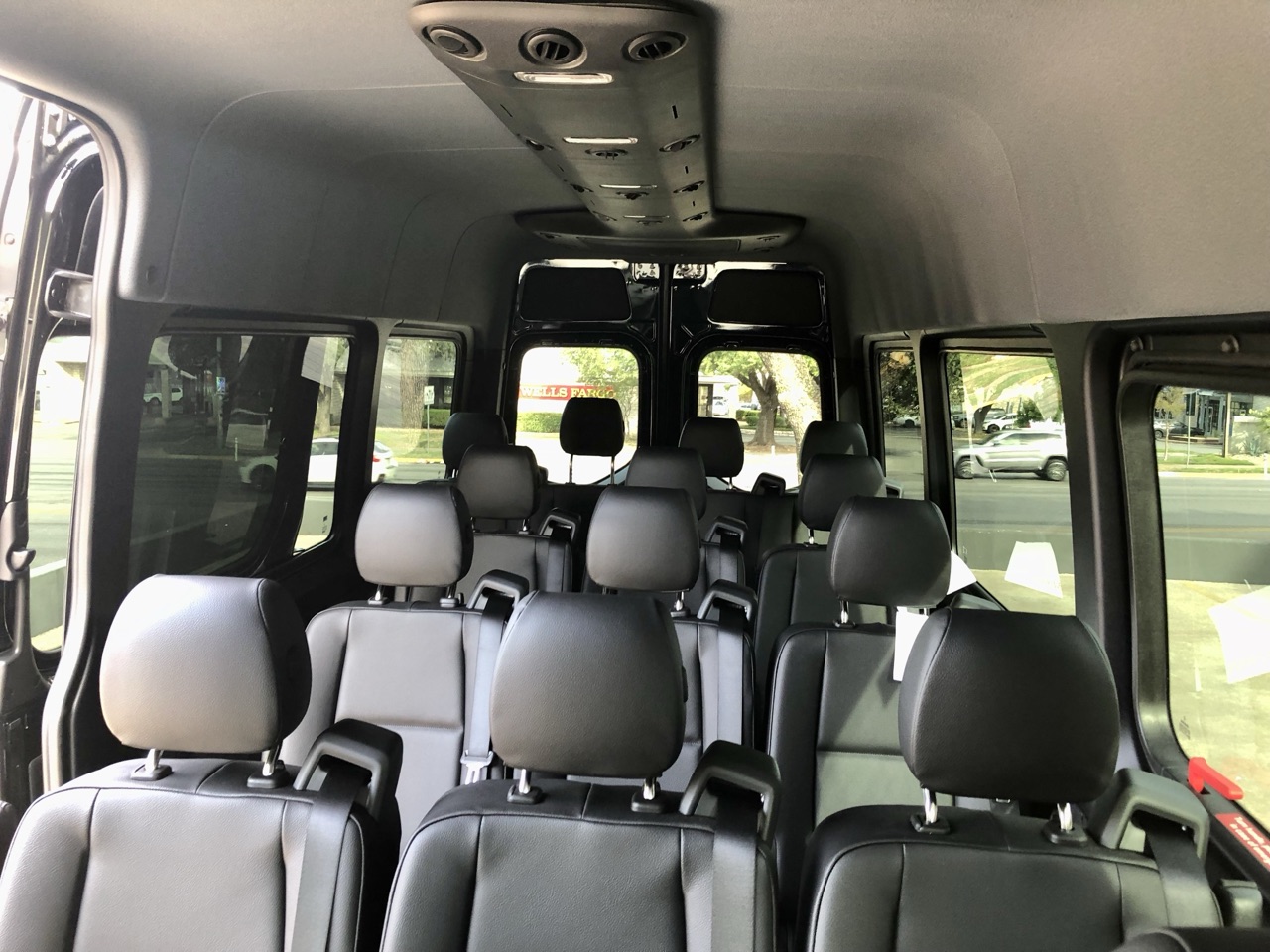 Mercedes-Benz Sprinter passenger van interior showing 15 leather seats and overhead AC vents — Austin van rental