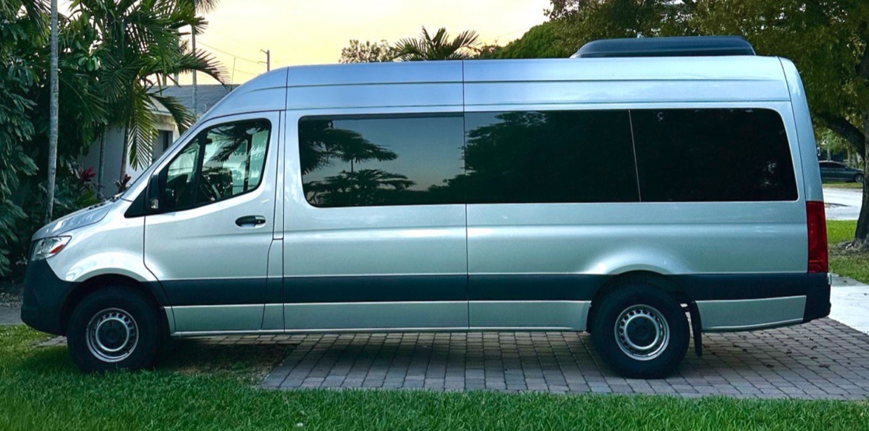 Silver Mercedes-Benz Sprinter high roof passenger van parked under palm trees at sunset — Sprinter Rentals Big Island van rental near Kailua-Kona