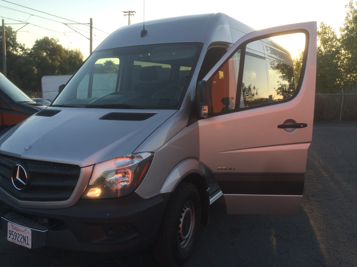 Silver Mercedes-Benz Sprinter 2500 passenger van with the driver door open — Big Island van rental pickup near KOA