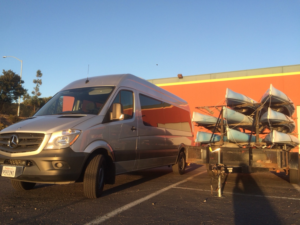 Silver Sprinter passenger van towing a kayak trailer — Big Island van rental for group gear and island day trips