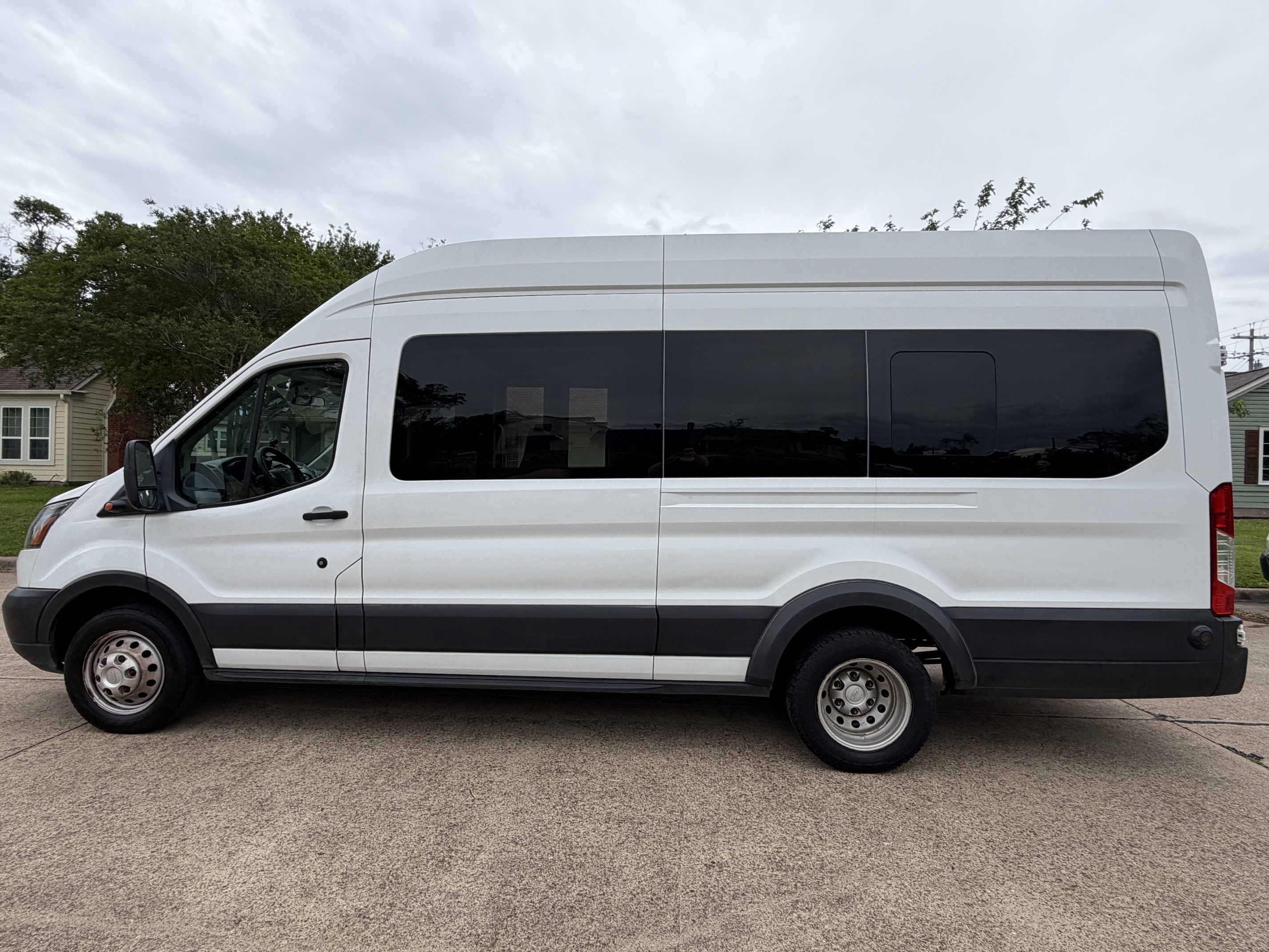 White Ford Transit tall-roof shuttle-style van rental in Eugene, Oregon