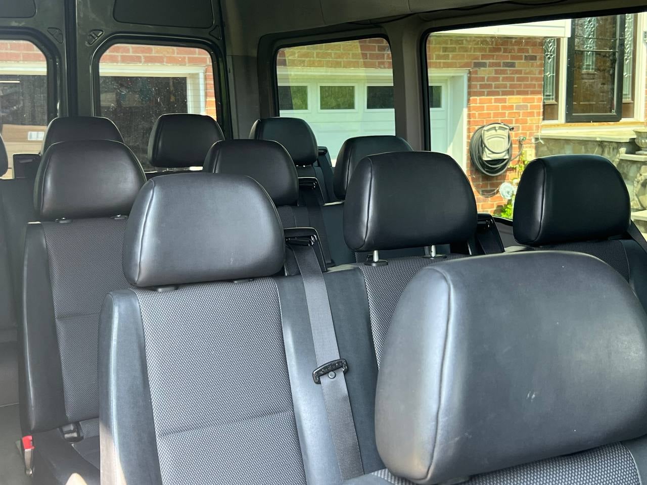 Interior passenger seating rows of a 15-passenger Sprinter van rental in New York