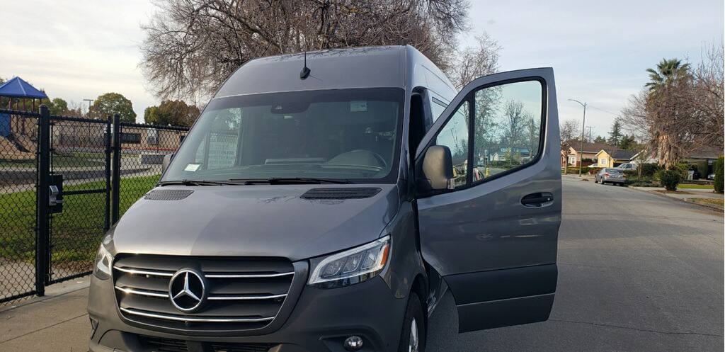 Mercedes-Benz Sprinter passenger van front grille and driver door — Sacramento, CA van rental fleet