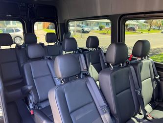 Black leather passenger seat rows inside the van
