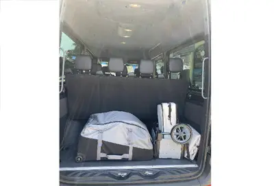 The cargo space of a 15-passenger Mercedes-Benz Sprinter van, showing ample room for luggage and gear