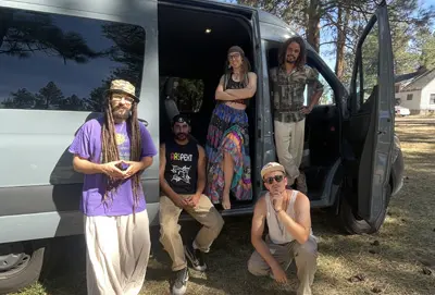 a group of people standing by a rented 5-passenger Mercedes-Benz Sprinter crew cargo van